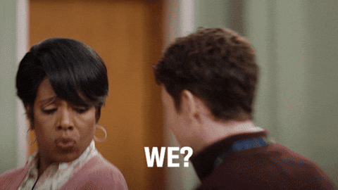 A woman gives a skeptical and surprised look as she turns to face a man, with the word "WE?" in bold text. Her expression suggests disbelief or questioning of a statement made by the man. The GIF humorously conveys confusion or shock at an unexpected suggestion or idea.